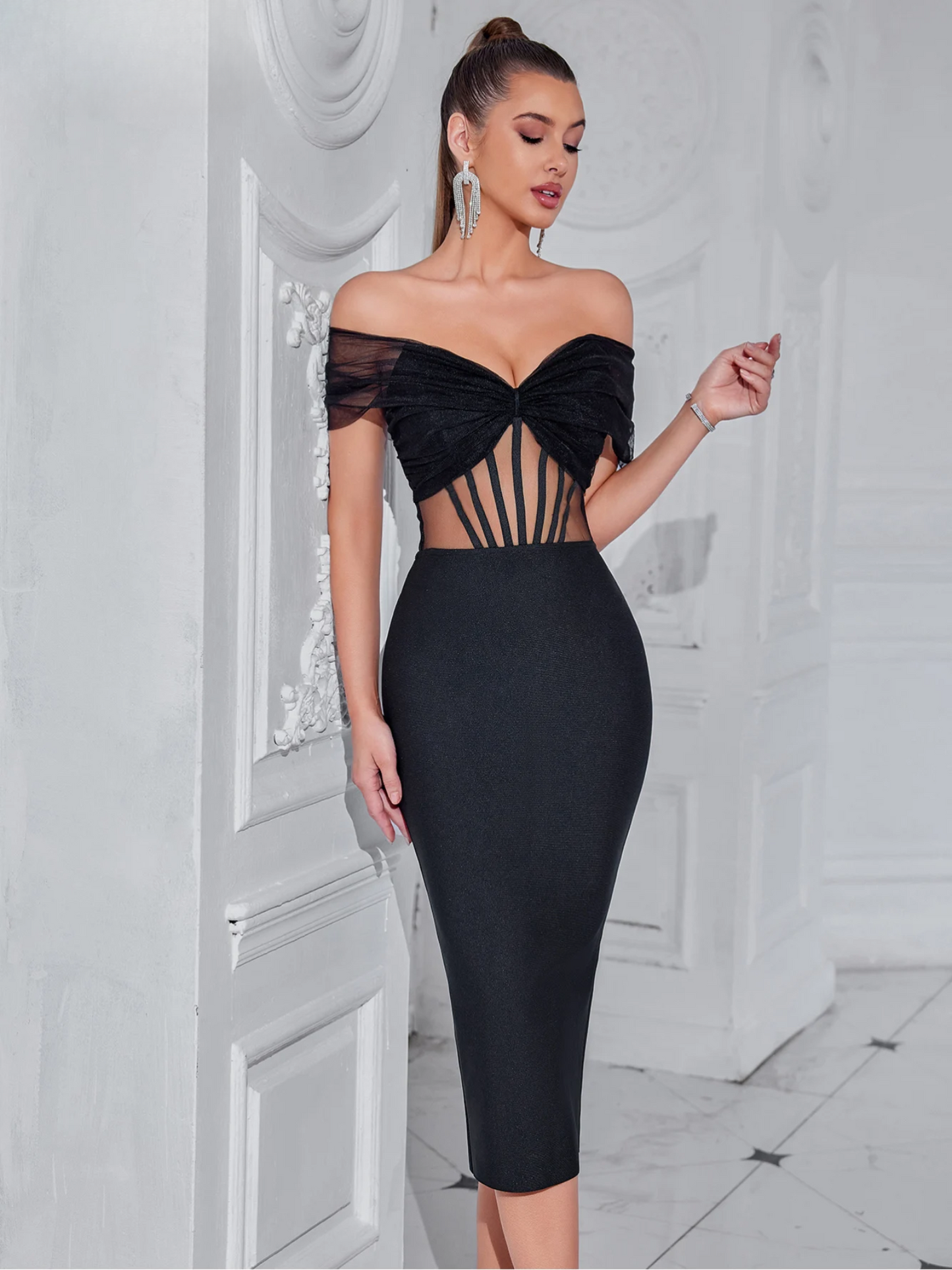 Nainen mustassa vartalonmyötäisessä mekossa, jossa on läpikuultava yläosa.