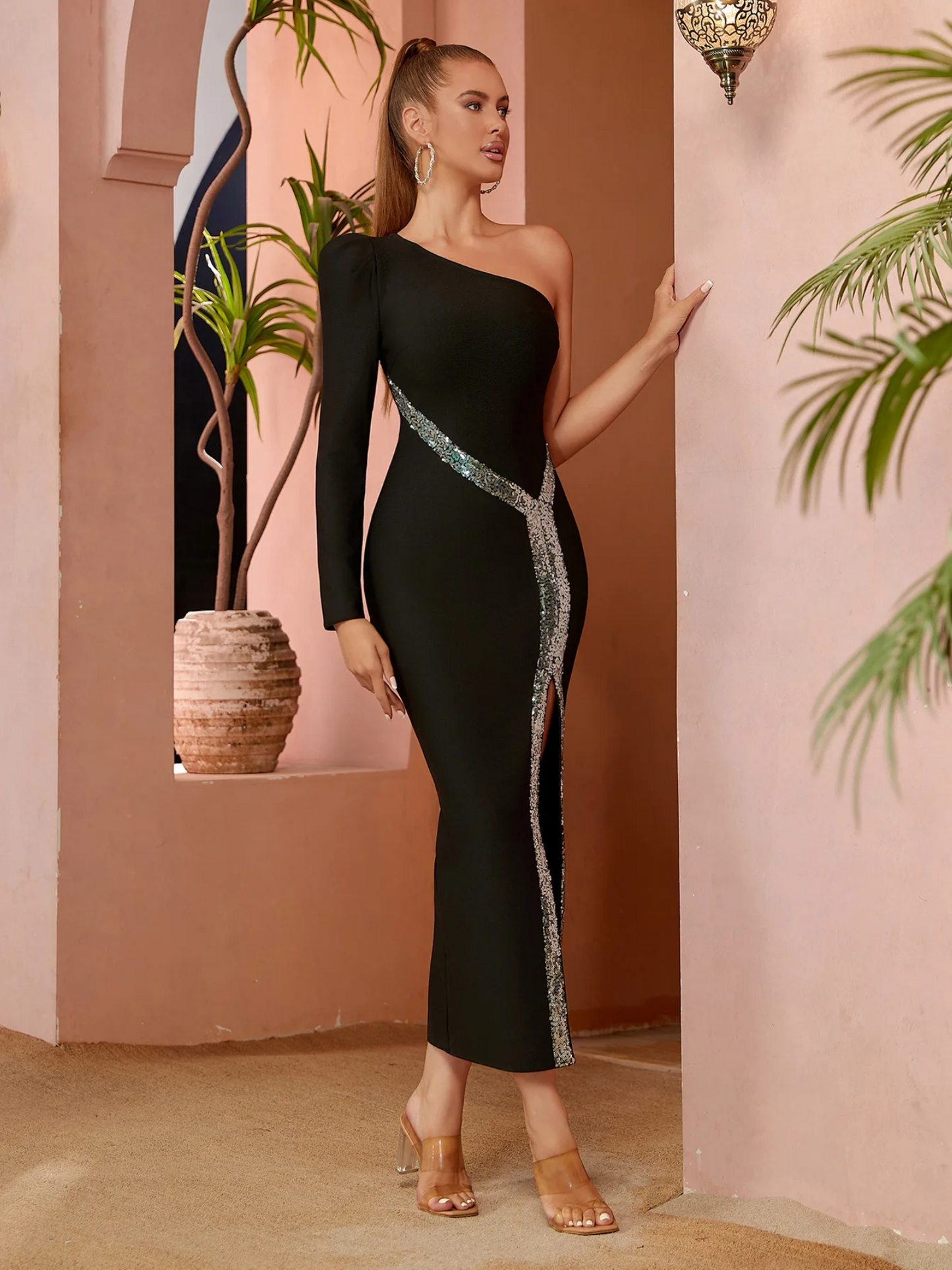 Edestä otettu kuva naisesta mustassa mekossa ja korkeassa halkiossa.