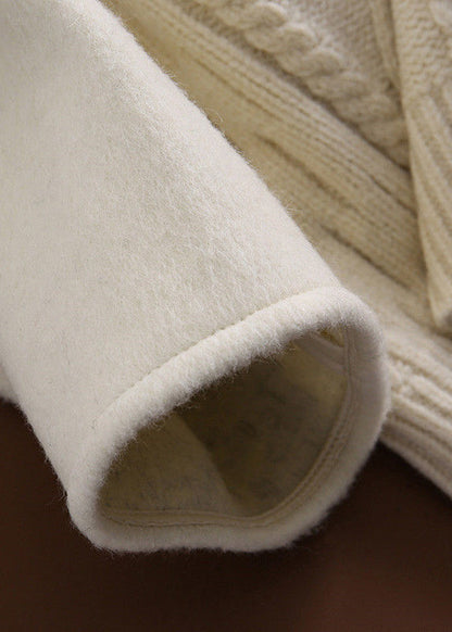 Luvik | Mustasta villasta valmistettu tilkkutakki napilla ja V-pääntiellä, pitkähihaisia