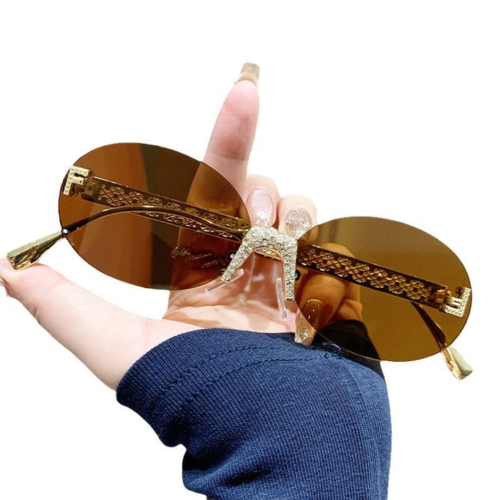 Dame solbrille med glitrende ramme og ovale glass Luvikno