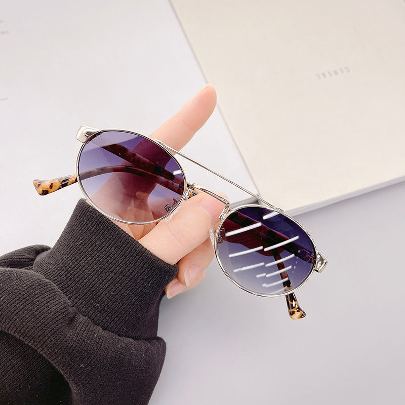 Dame moteriktig solbrille i stilfullt rundt design med gull aksenter Luvikno