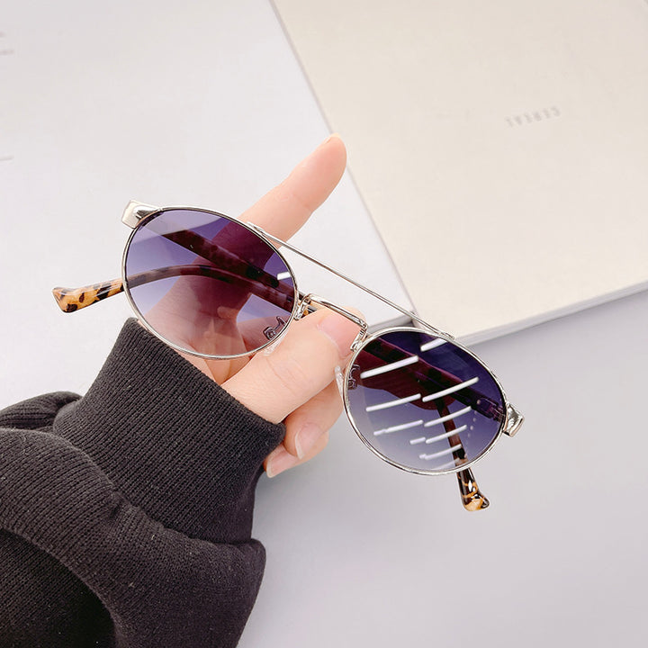 Dame moteriktig solbrille i stilfullt rundt design med gull aksenter Luvikno