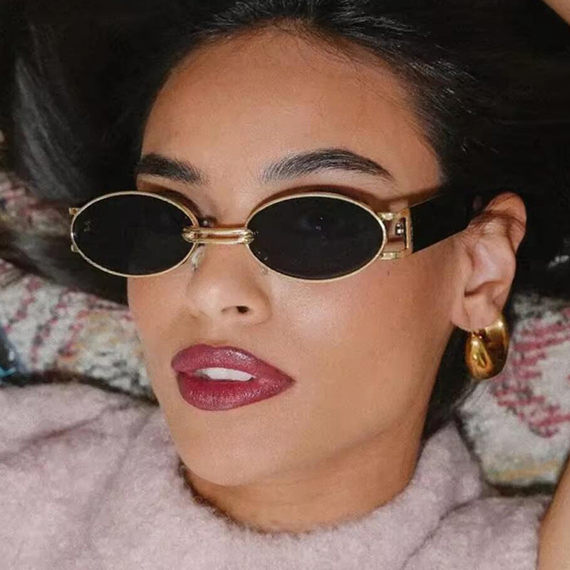Dame ovalformet solbrille med gullige accenter og stilig ramme Luvikno