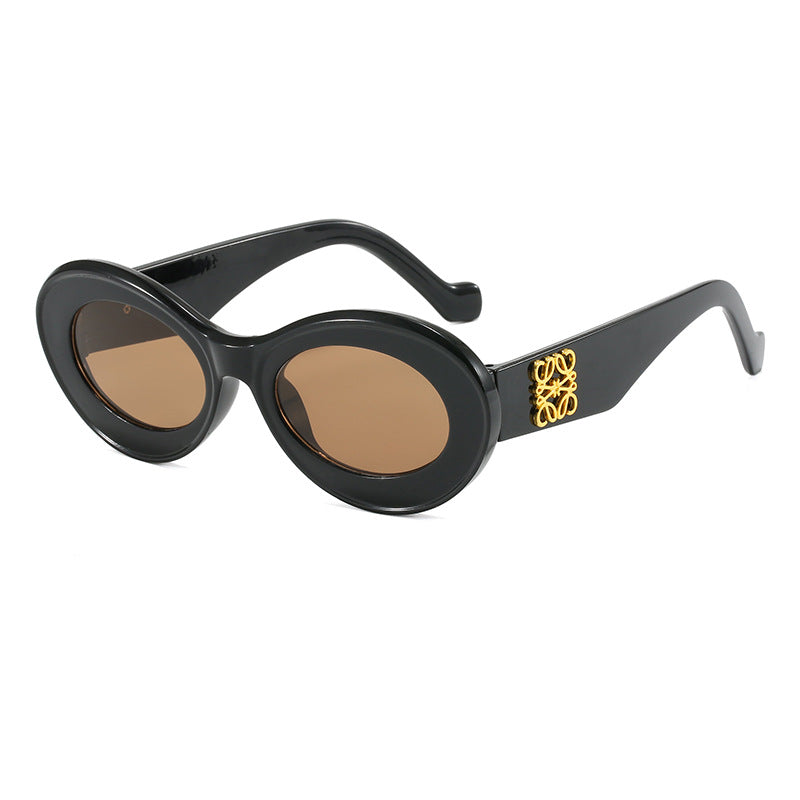 Dame moteriktig solbrille med oval ramme og gullapplikasjoner Luvikno