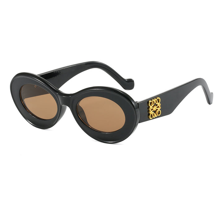 Dame moteriktig solbrille med oval ramme og gullapplikasjoner Luvikno