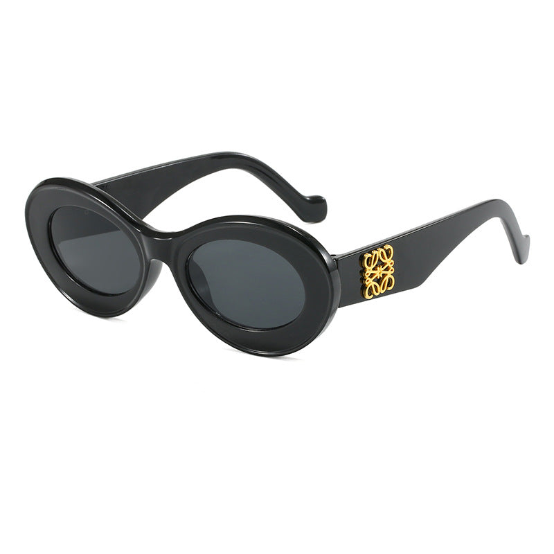 Dame moteriktig solbrille med oval ramme og gullapplikasjoner Luvikno