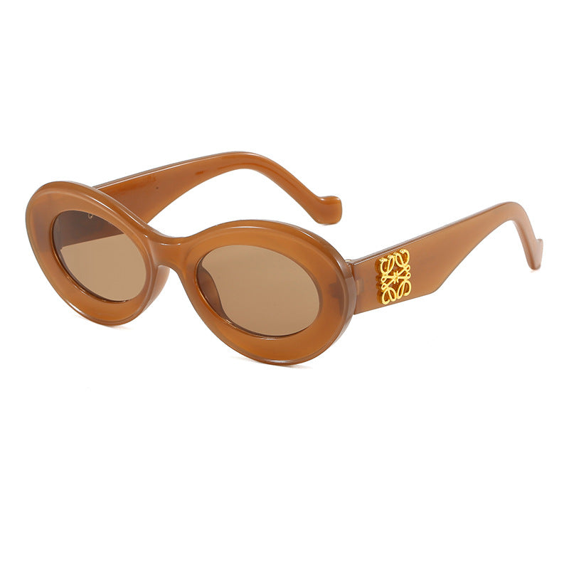 Dame moteriktig solbrille med oval ramme og gullapplikasjoner Luvikno