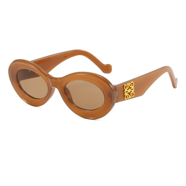 Dame moteriktig solbrille med oval ramme og gullapplikasjoner Luvikno