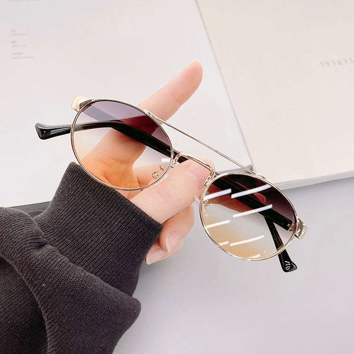 Dame moteriktig solbrille i stilfullt rundt design med gull aksenter Luvikno