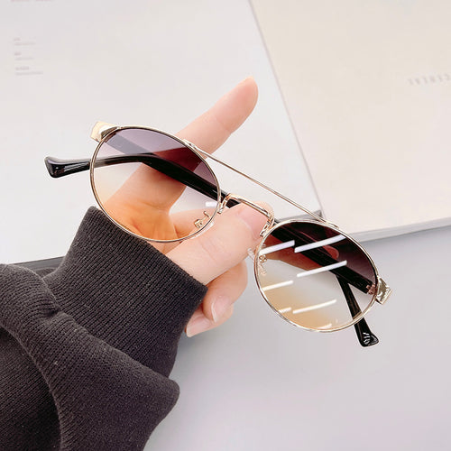 Dame moteriktig solbrille i stilfullt rundt design med gull aksenter Luvikno