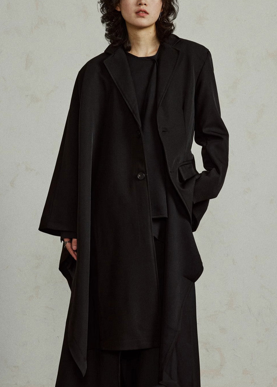 Luvik | Pitkät mustat takit, joissa on epäsymmetrisiä lovipusseja ja viittahihnat